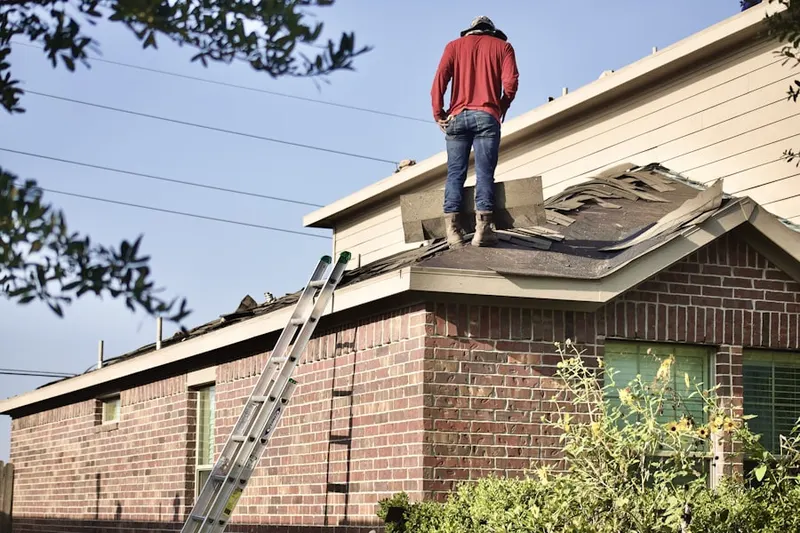 Professional roofer working on a residential roof in Rockfall